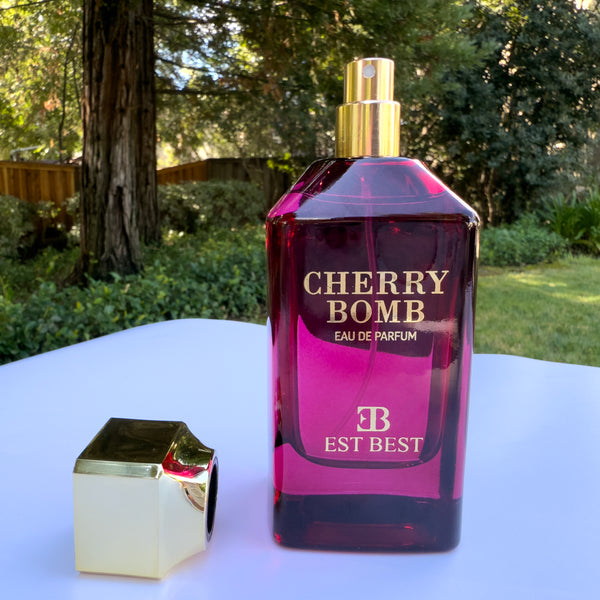 Cherry Bomb Eau de Parfum photographed outdoors under natural light, highlighting its elegant ruby-red bottle and gold atomizer cap.