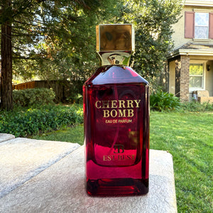 Cherry Bomb perfume 100ml bottle by EST BEST captured outdoors with natural background, showcasing its luxurious design.