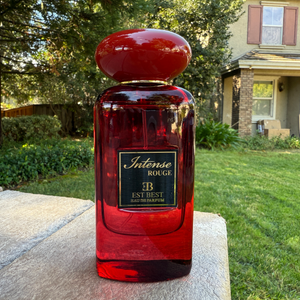 INTENSE ROUGE perfume bottle photographed outdoors – elegant red glass design by EST BEST