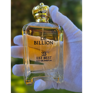 Close-up of DE BILLION perfume bottle held by hand wearing a white glove, elegant and refined presentation.