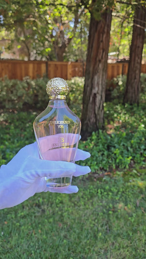 Close-up video of DELICIOUSLY YOU by EST BEST Eau de Parfum being sprayed outdoors, highlighting the pink fragrance and golden details in natural sunlight.